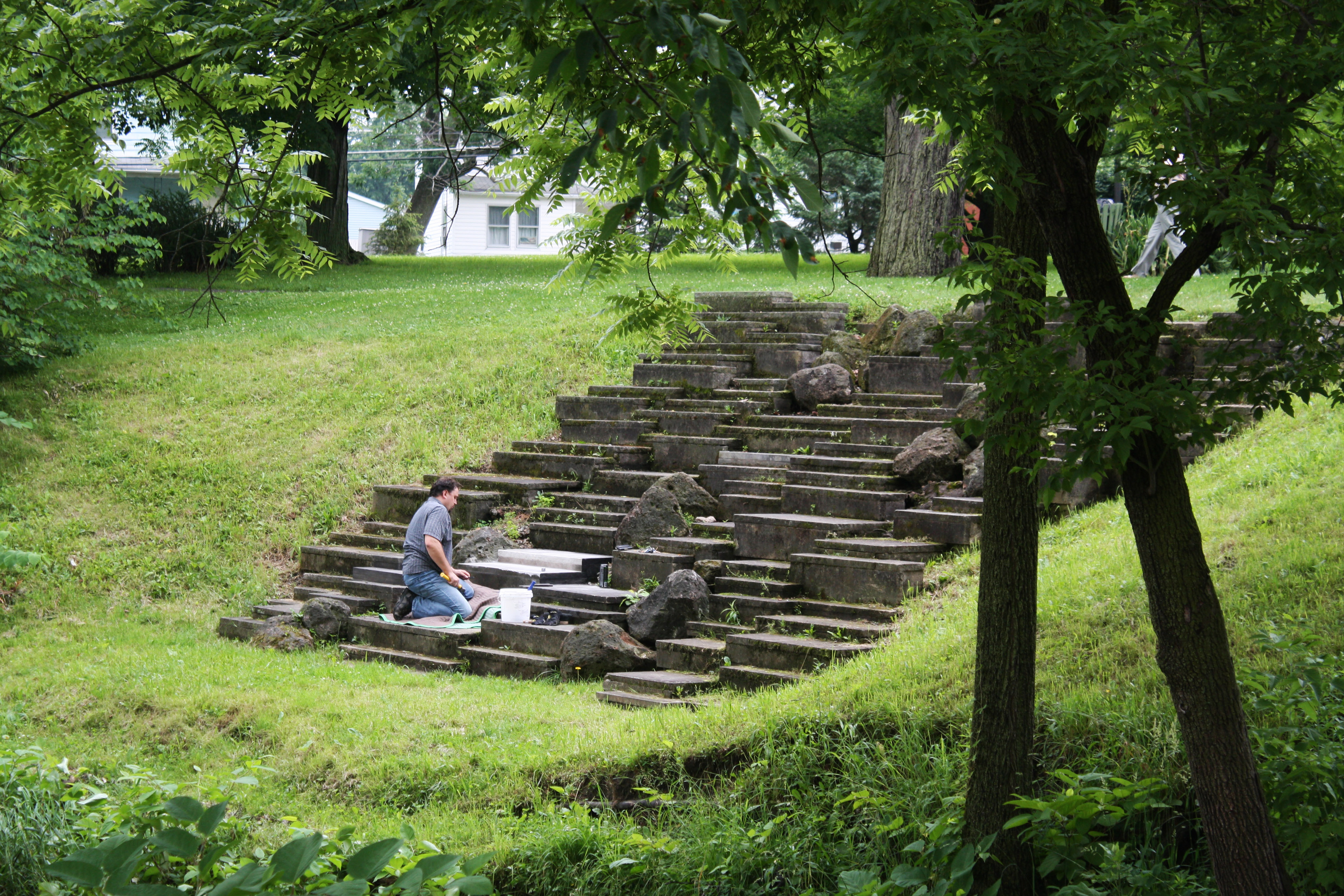 A local stonecutter works to beautify a creek-side park.